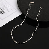 Collana in oro bianco con motivo a onda intrecciata