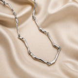 Collana in oro bianco con motivo a onda intrecciata
